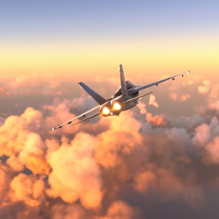 Militar,Aircraft,Flying,Over,The,Clouds,In,Amazing,Sunset
